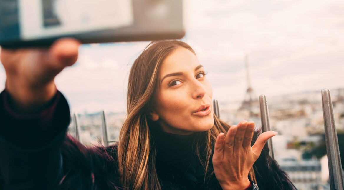 Junge Frau dreht Video mit dem Smartphone.