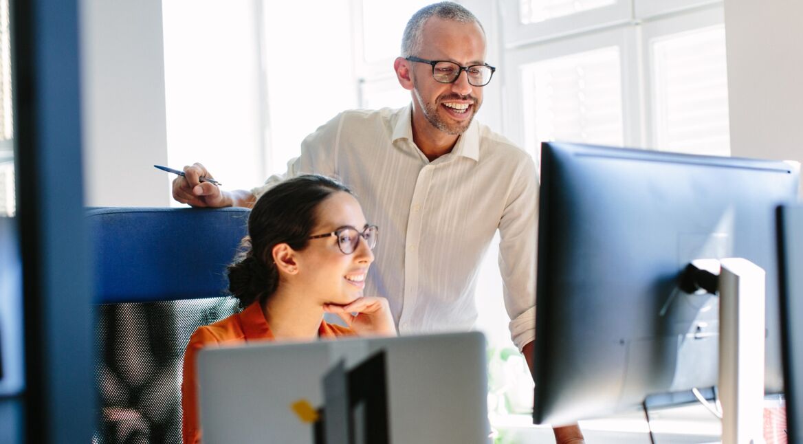 Zwei Kollegen verfassen über Gmail eine Mail an einen Geschäftspartner