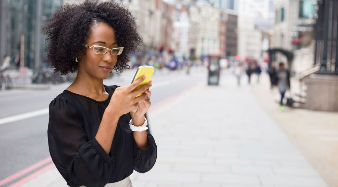 Junge Frau schreibt Nachrichten auf ihrem Smartphone.