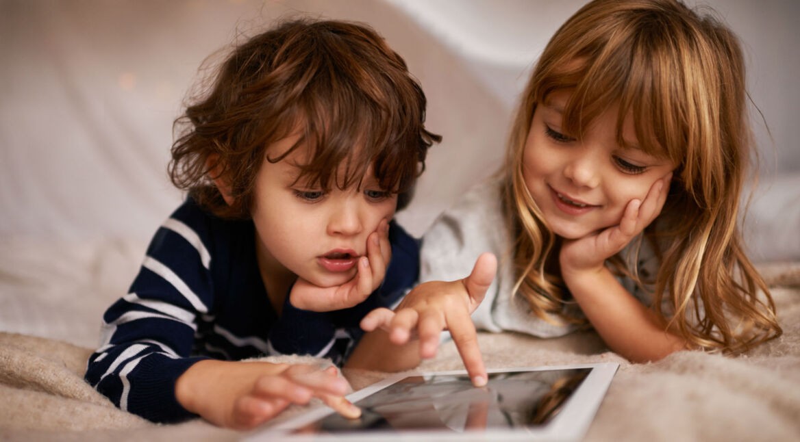 Zwei Kinder spielen ein Mobile Game via Tablet.