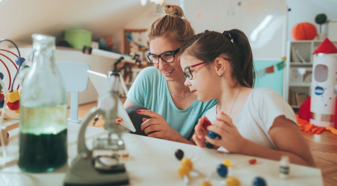 Mutter und Kind spielen am Tablet.