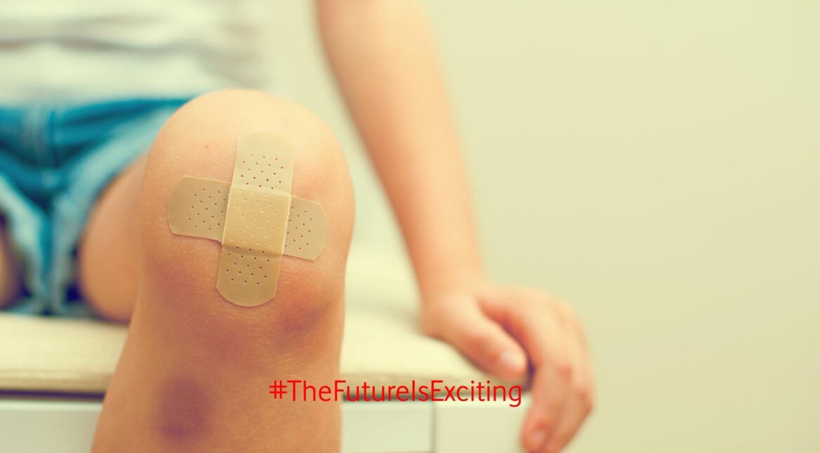 Child knee with an adhesive bandage and bruise.