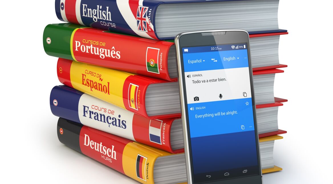 Aufgetürmte Wörterbücher neben einem Smartphone