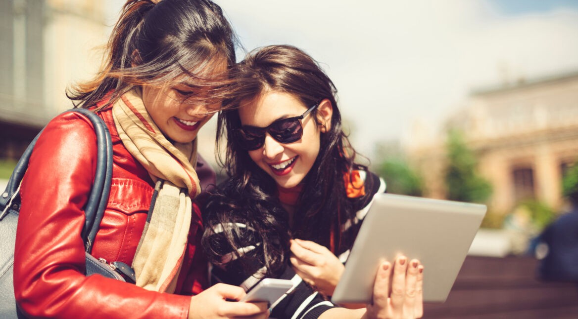 Junge Frauen zeigen sich gegenseitig ihre Bildersammlung