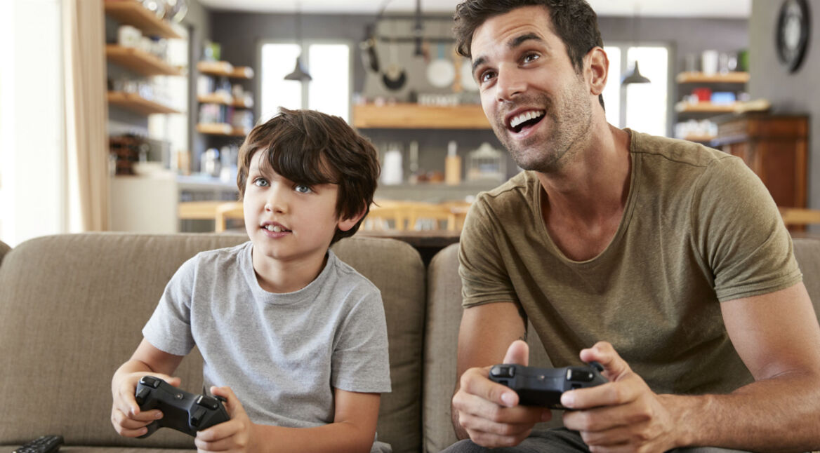 Vater spielt mit Sohn an der Konsole