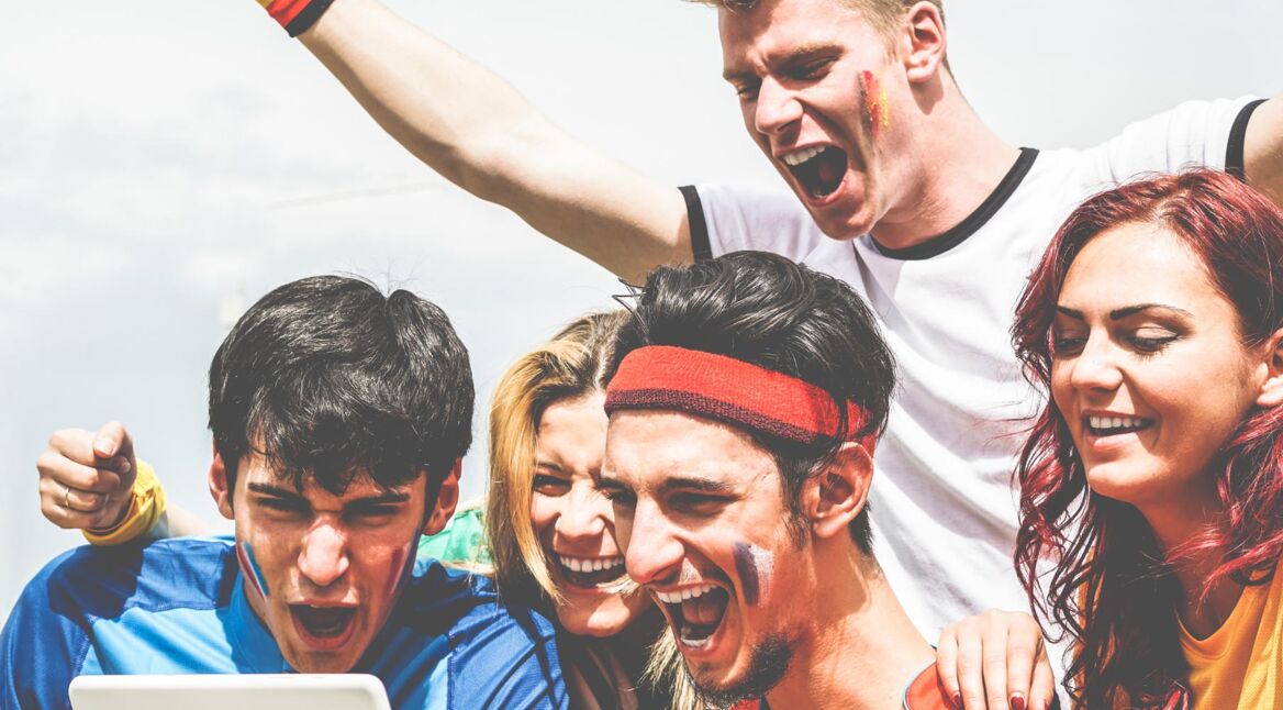 Happy supporters from different countries watching football sport on notepad tablet computer - Main focus on center bottom man - Crazy fan celebrating a goal in world soccer game - Gathering concept