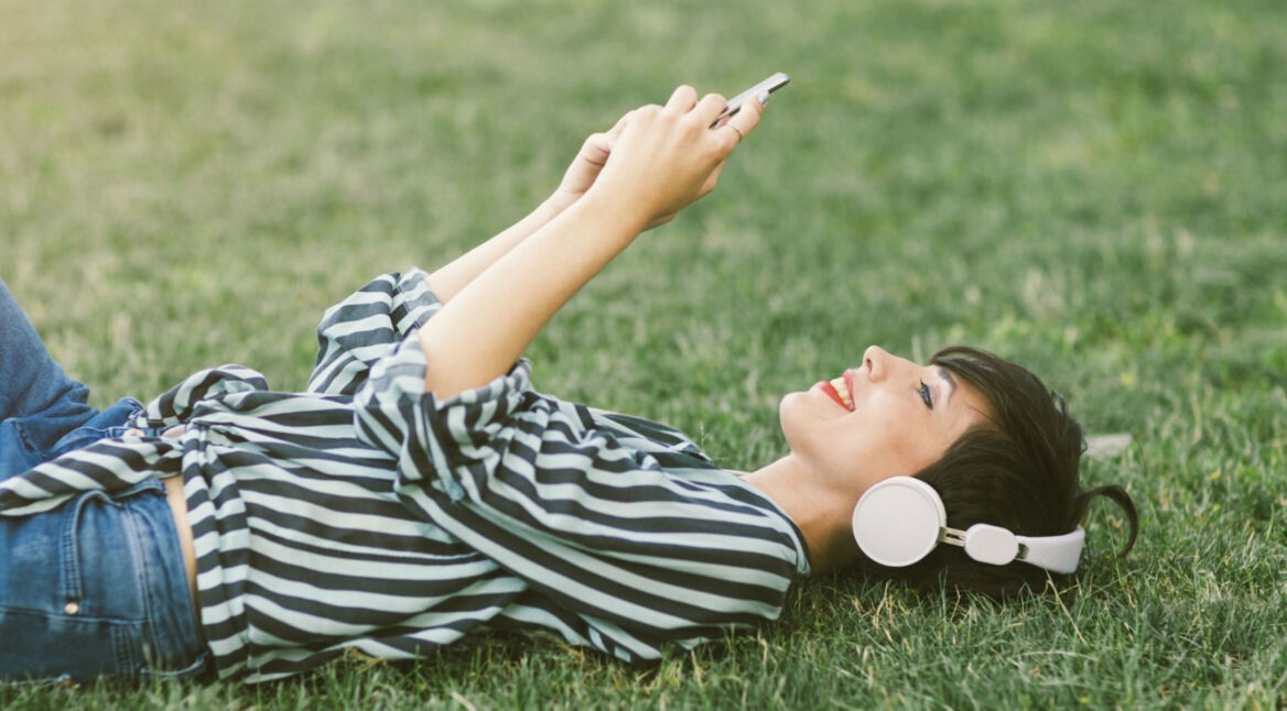 Junge Frau schaut Videos auf dem Smartphone an.