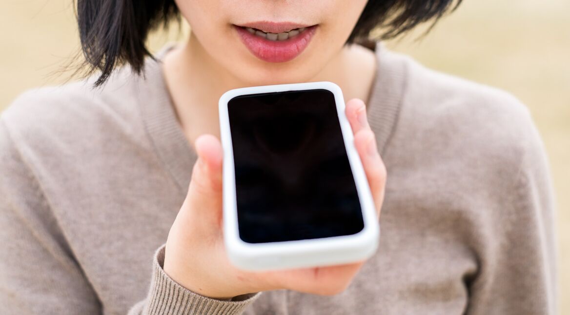 Junge Frau spricht mit Google Assistant