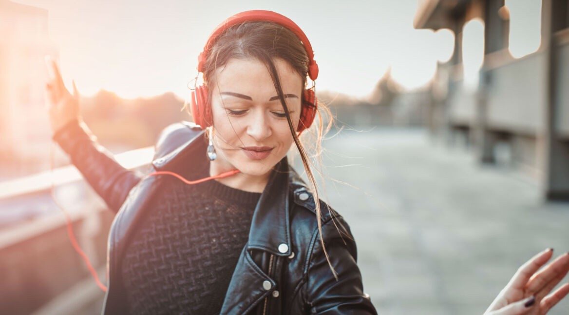 Junge Frau hört Musik über Kopfhörer.