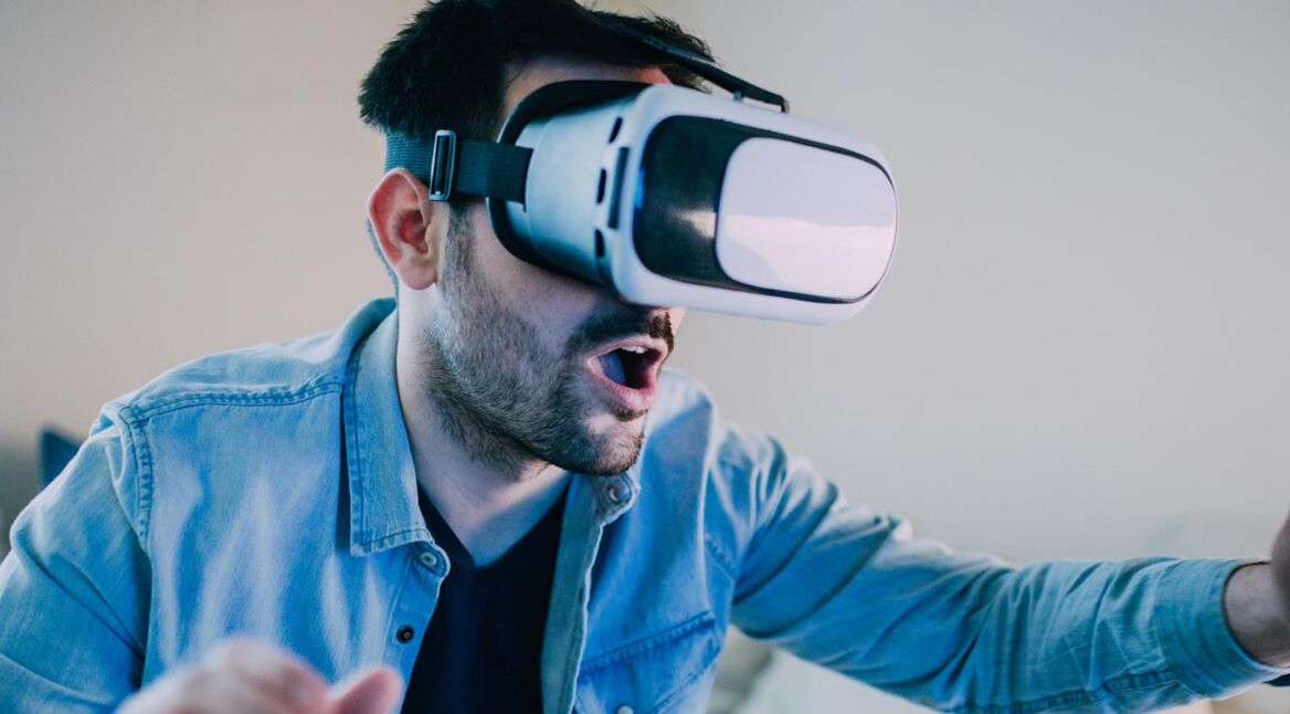 Man with mouth open wearing virtual reality glasses