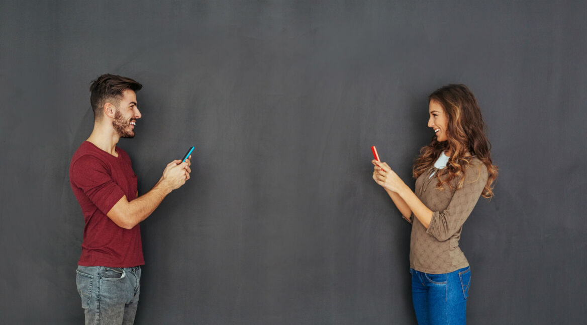 Mann und Frau chatten via Smartphone.