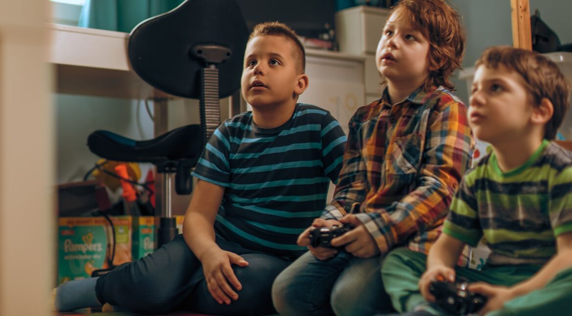 Drei Kinder spielen auf der Xbox One