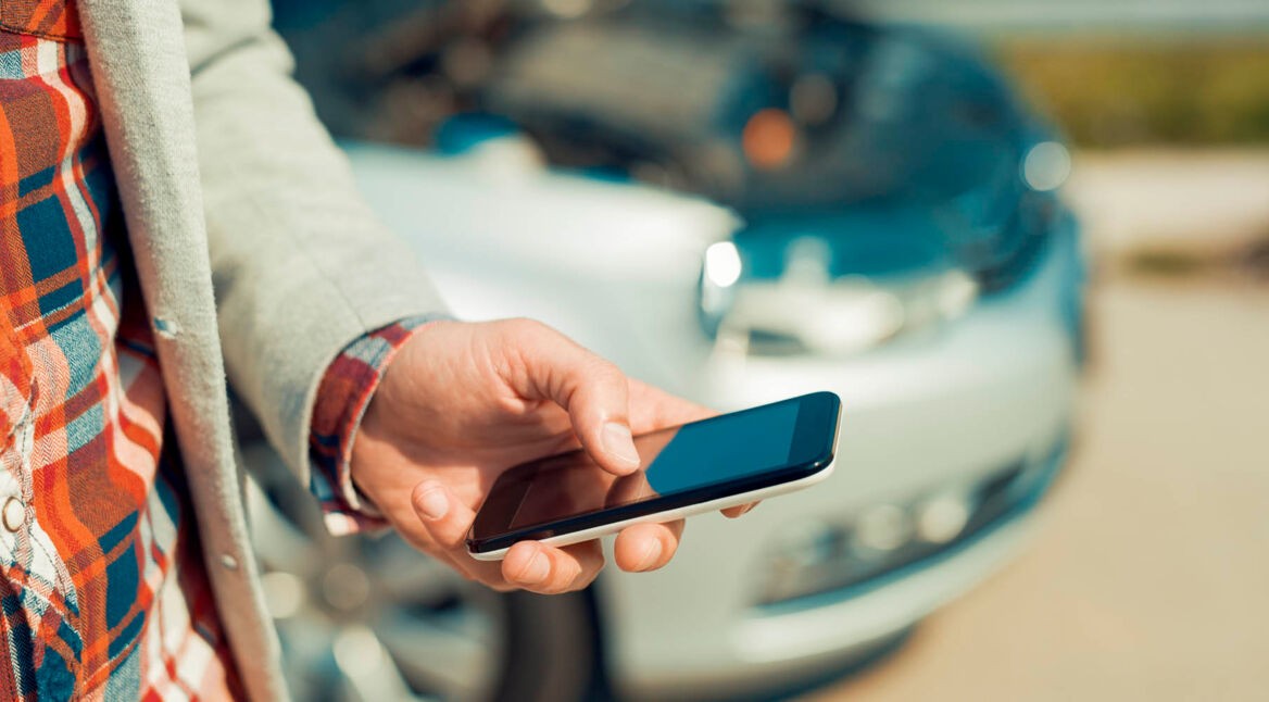 Man using smartphone after traffic accident