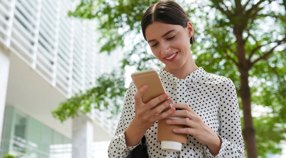 Frau lädt Dateien über ihr Smartphone in die Cloud hoch.