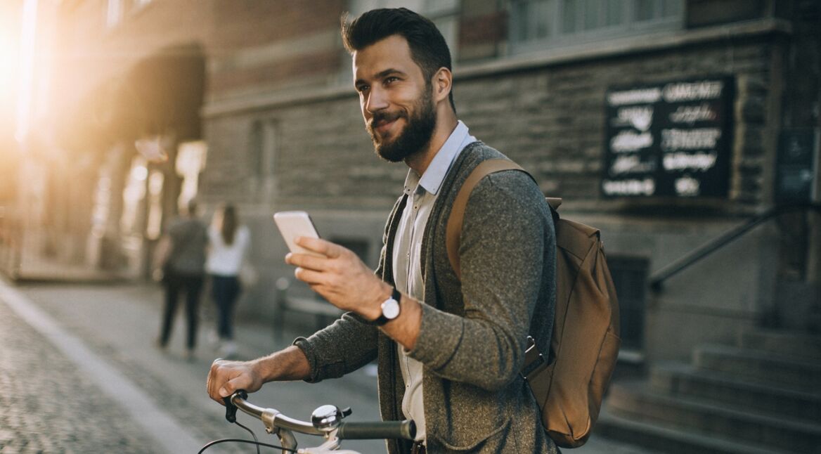 Ein junger Mann scrollt auf seinem Smartphone seinen Facebook-News Feed durch