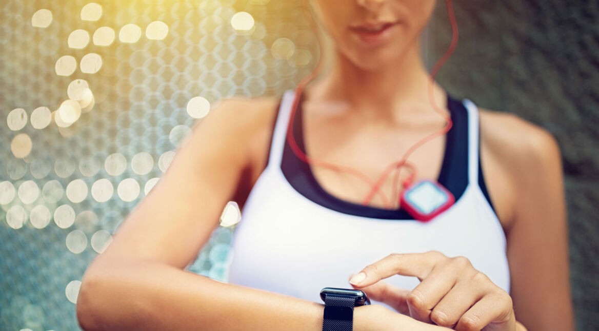 Frau nutzt während des Lauftrainings ihre Smartwatch.