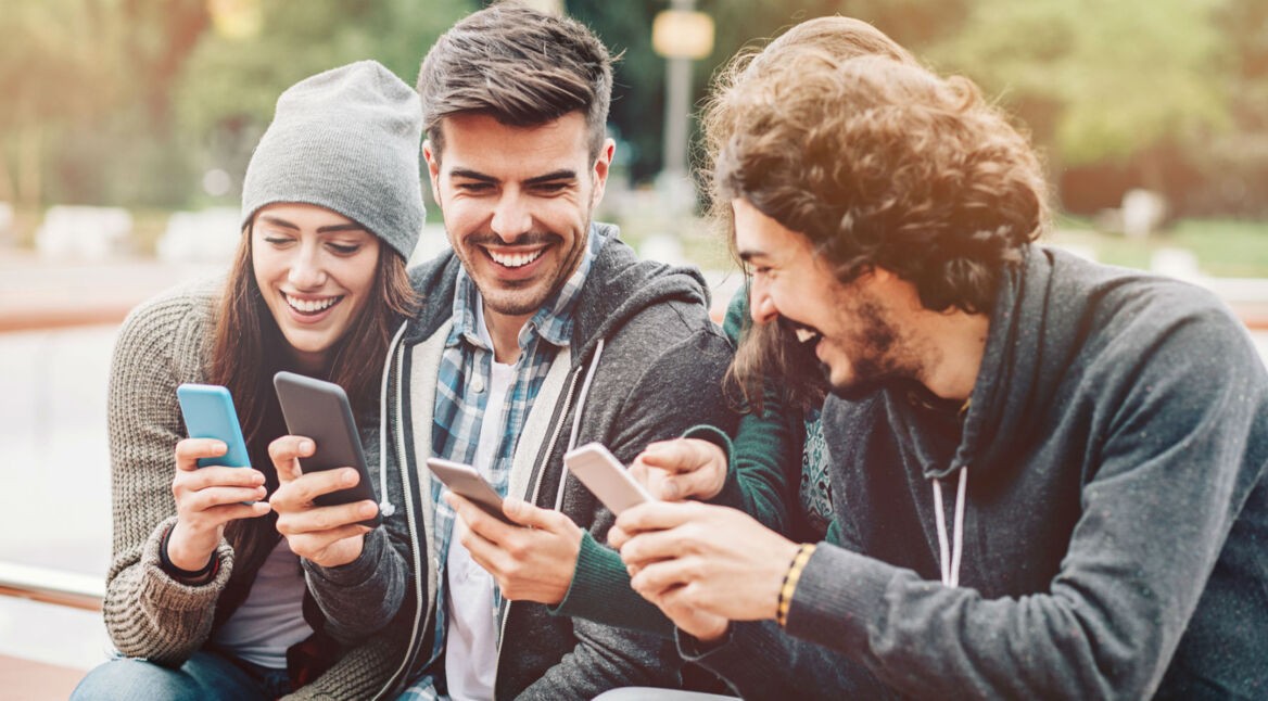 Freunde chatten via WhatsApp am Smartphone.