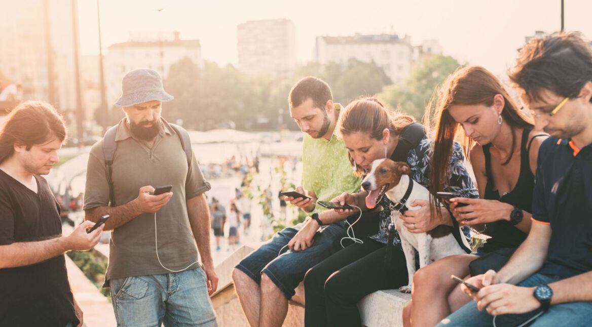 Freunde laden ihre Smartphones über eine Powerbank auf.