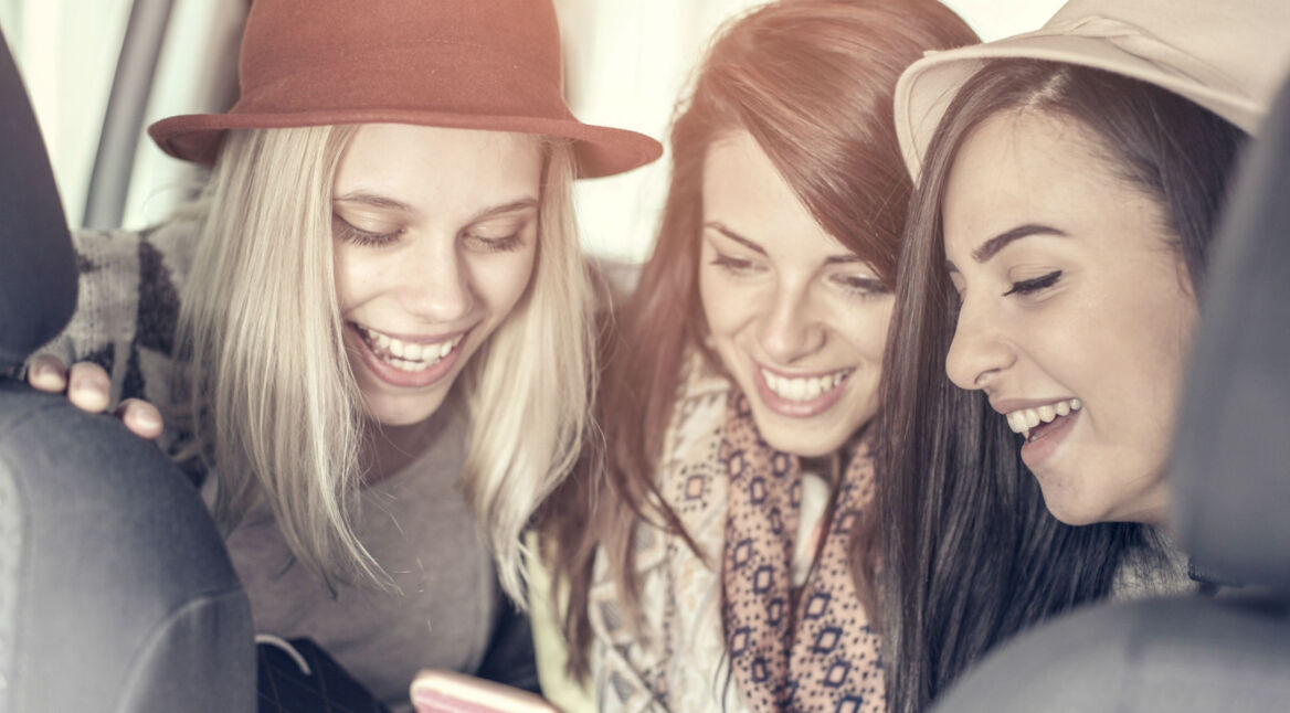 Drei Freundinnen diktieren eine WhatsApp-Nachricht.