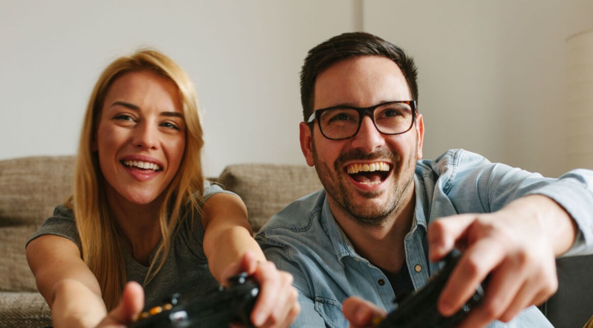 Junges Paar zockt über ihre Konsole.