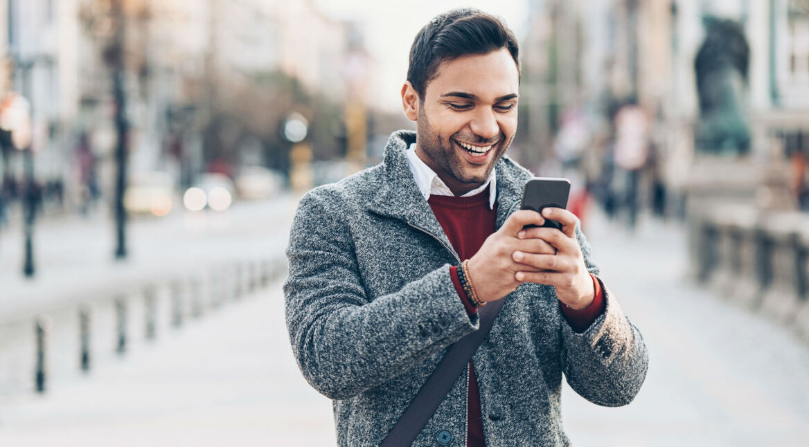 Junger Mann testet am Smartphone die neuen WhatsApp-Funktionen.