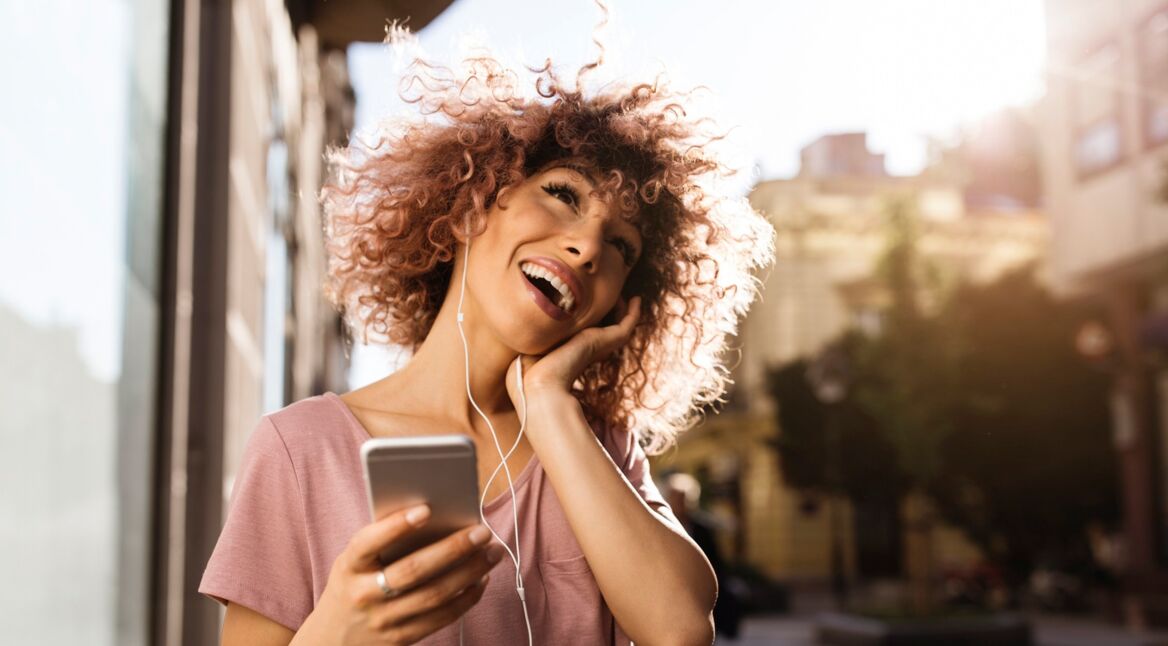 Eine junge Frau hört Spotify über die App