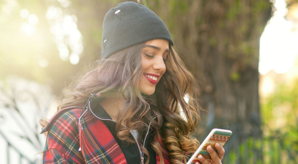 Junge Frau nutzt ihr Android-Smartphone mit Notch.