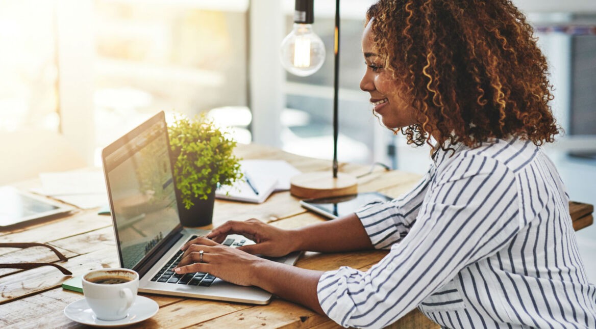 Junge Frau nimmt Social Logins am Computer in Anspruch.