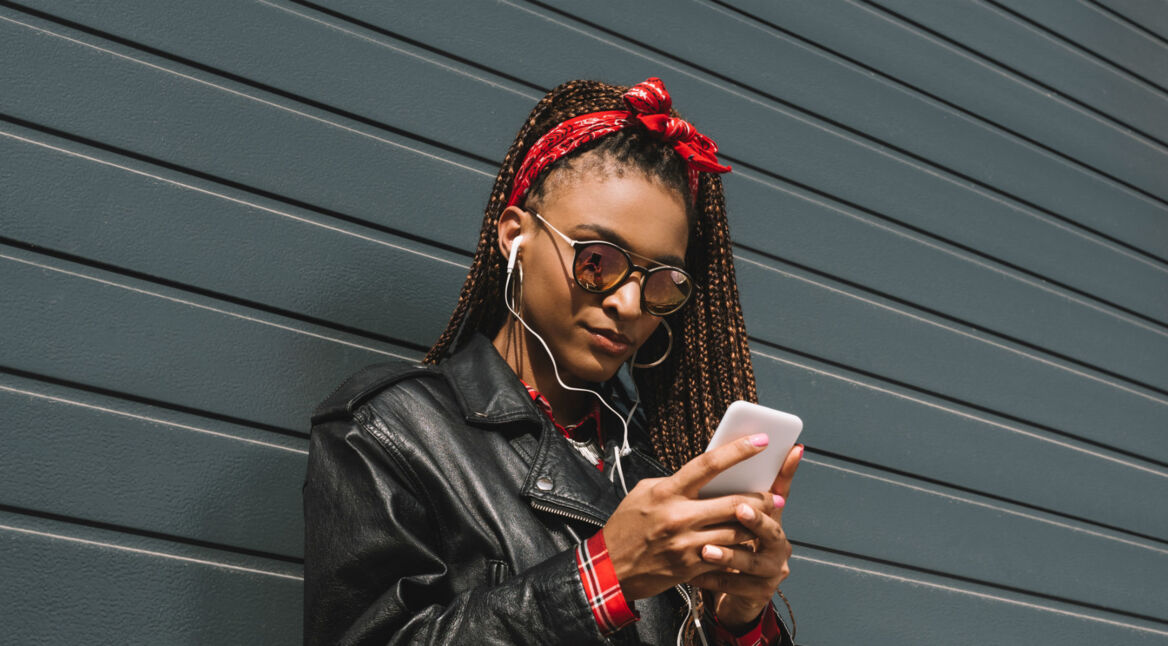 Junge Frau löscht den Cache der Spotify-App auf ihrem Smartphone.