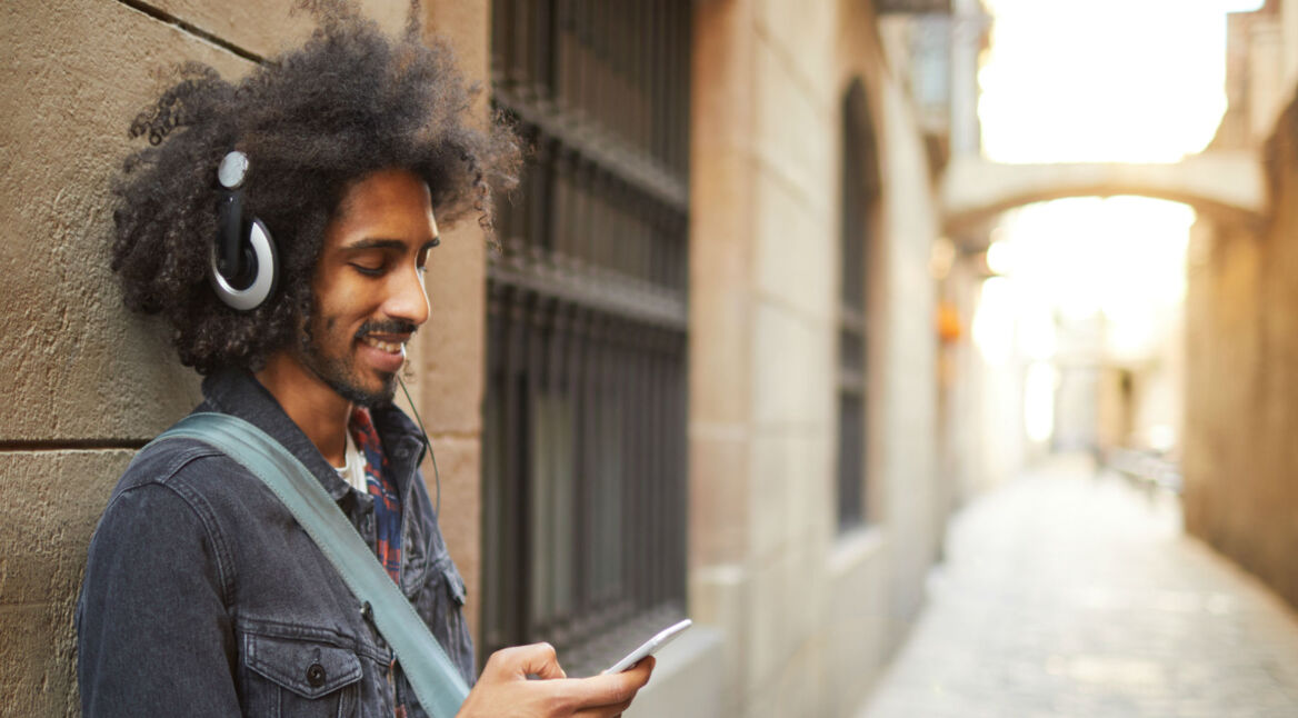 Junger Mann hört Musik mit Spotify auf dem Samsung-Smartphone.