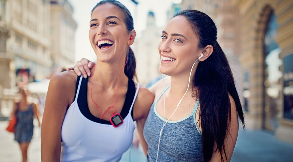 Zwei junge Frauen erholen sich kurz von einer anstrengenden Laufrunde