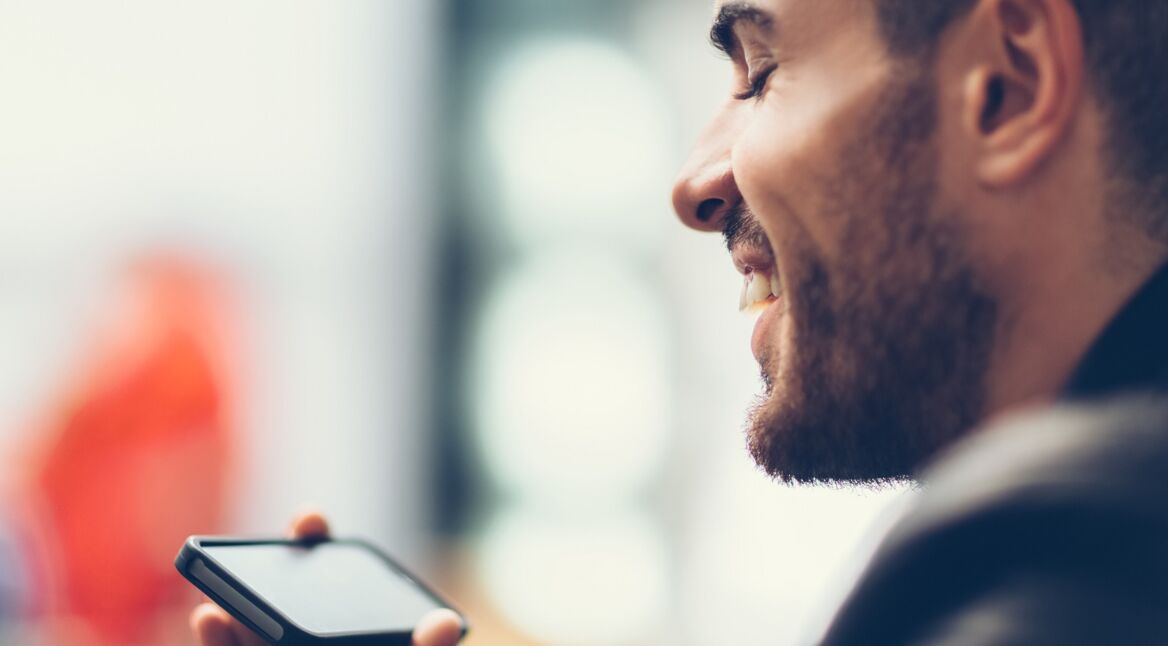 Ein junger Mann schaut sich ein Video auf seinem iPhone an