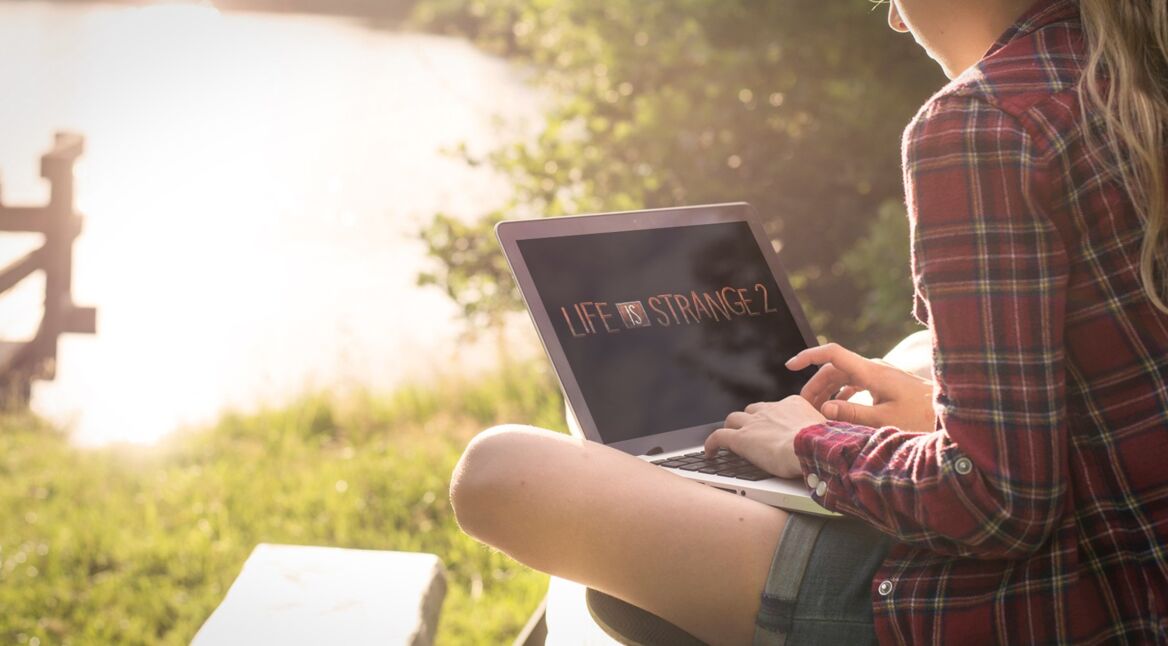 Mädchen spielt Life is Strange 2 am See