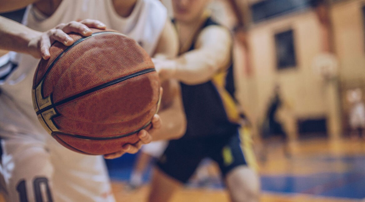 Zwei junge Spieler spielen Basketball.