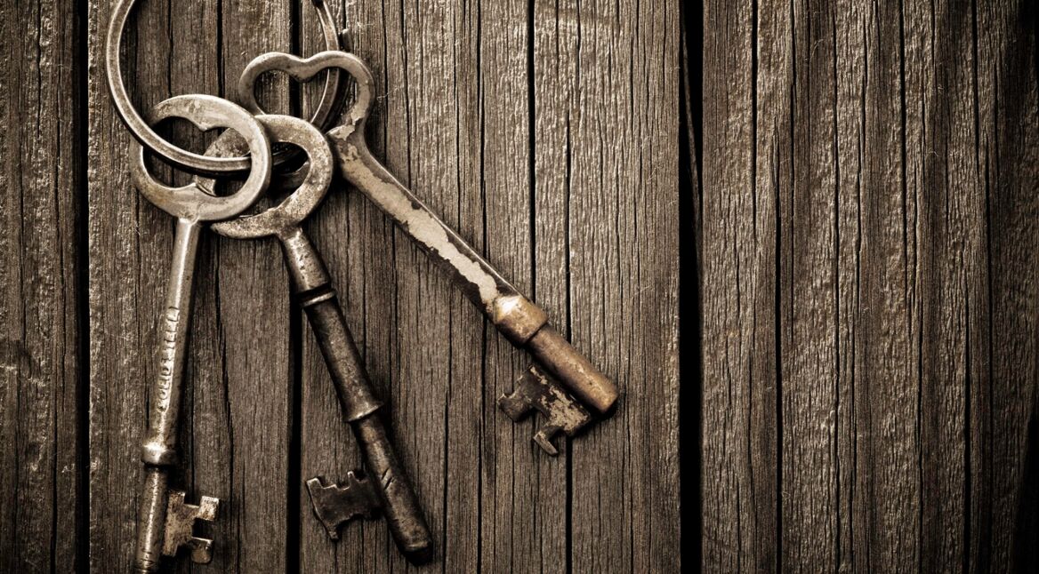 Alte Schlüssel, die an einer Tür hängen