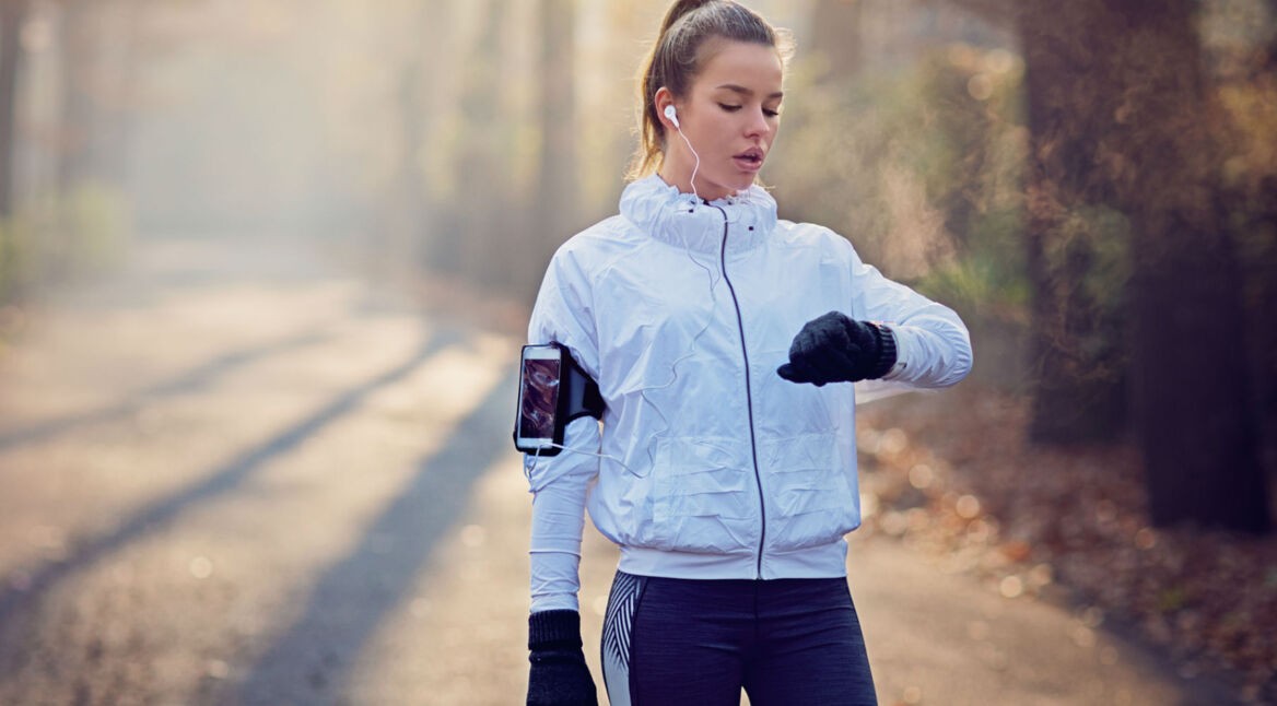 Junge Frau zeichnet ihre Laufaktivitäten mit der Apple Watch auf.