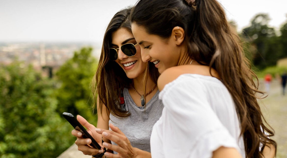 Freundinnen suchen am Smartphone nach einer Google-Inbox-Alternative.