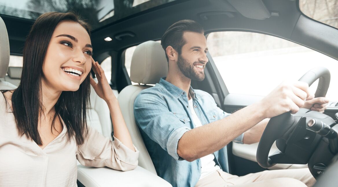 Ein junges Pärchen fährt mit dem Auto und navigiert über Google Maps