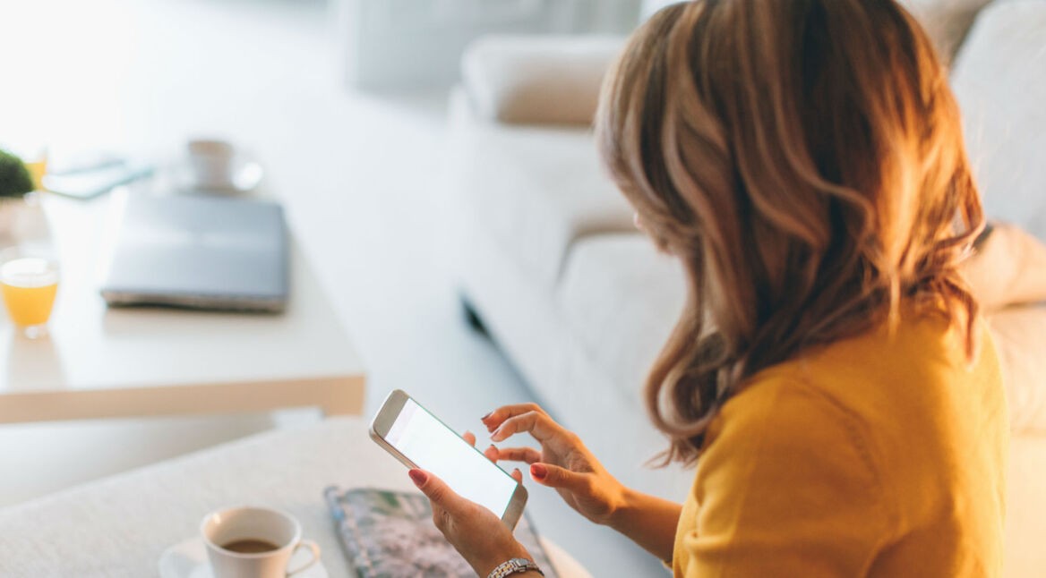 Junge Frau fügt Passwörter am Smartphone via Autofill-Funktion ein.