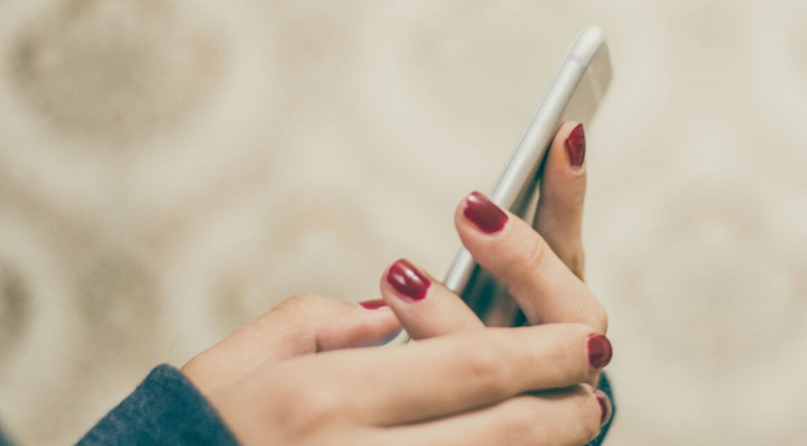 Junge Frau löst ihre iMessage-Probleme am Smartphone.