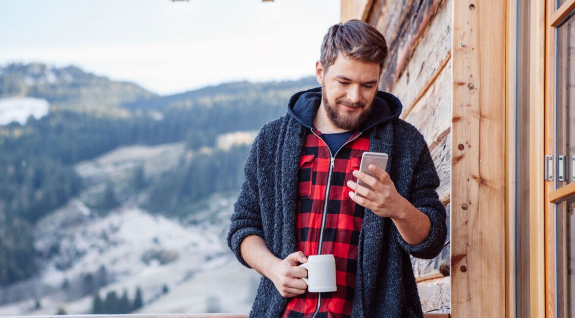 Junger Mann testet am iPhone unter iOS 12 die neue Fotos-App.