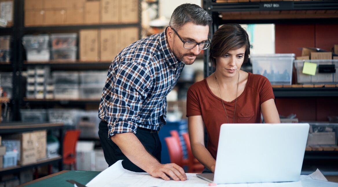 Zwei Kollegen bereiten eine Datenübertragung von Windows auf einen Mac vor