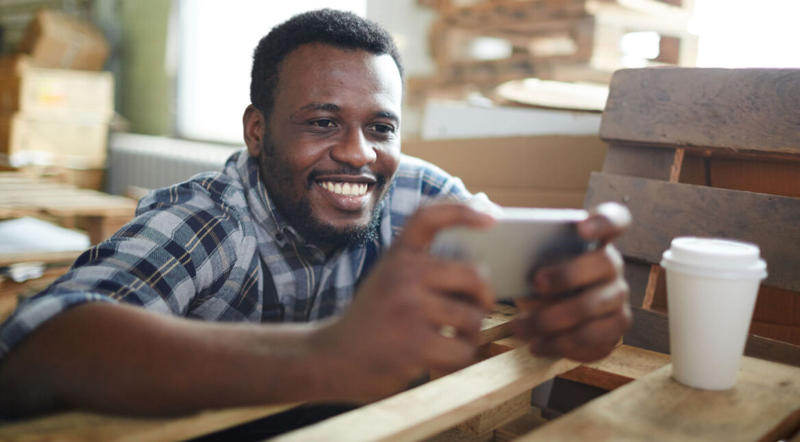 Junger Mann spielt auf seinem Smartphone