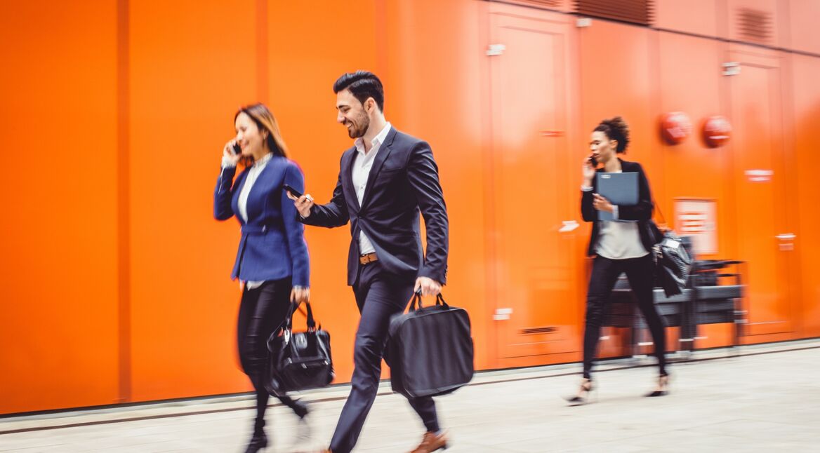 Junge Geschäftsleute checken ihre Termine im iOS-Kalender