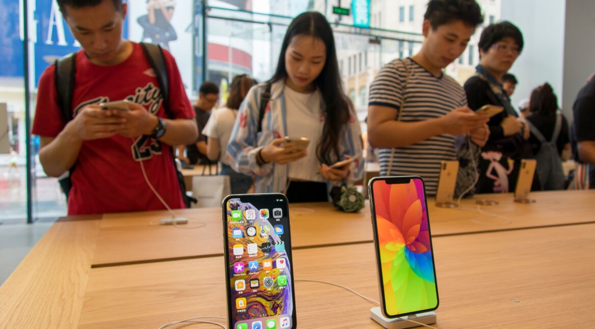 Kunden im Apple Store Shanghai hinter iPhone XS und XS Max