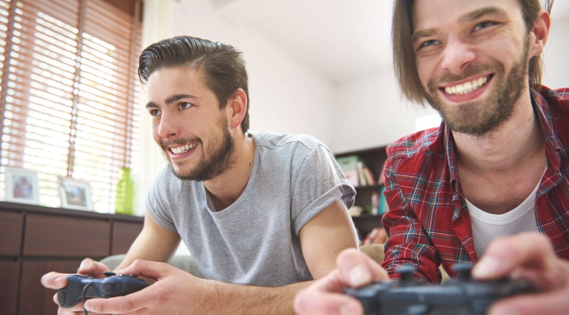 Zwei Männer spielen PlayStation 4