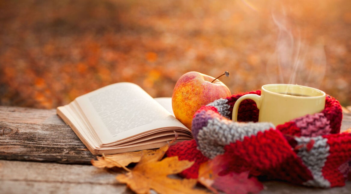 Buch liegt im Herbst auf einem Tisch.