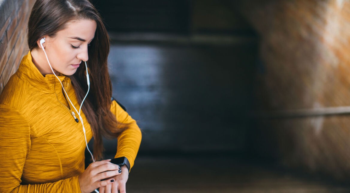 Junge Frau schaltet das haptische Feedback ihrer Smartwatch aus.