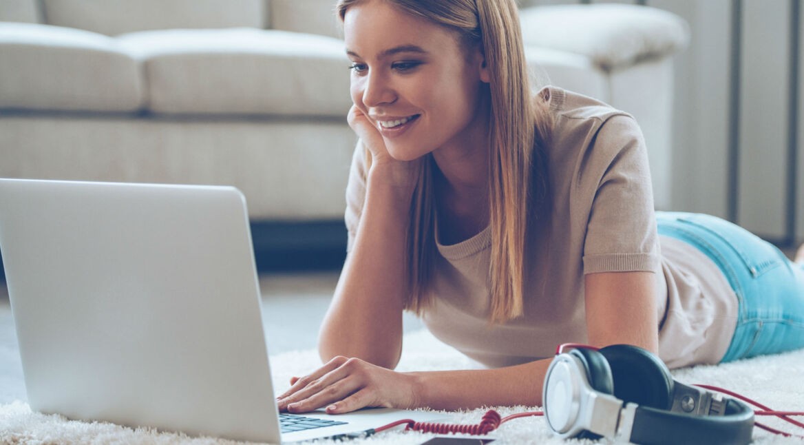 Junge Frau löst die Ton-Probleme ihres Laptops.
