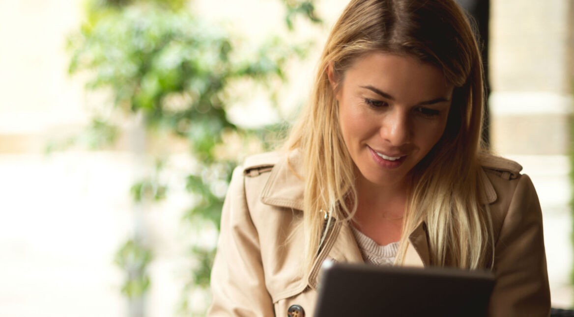 Junge Frau passt Apple Books beim Lesen auf dem Tablet an.